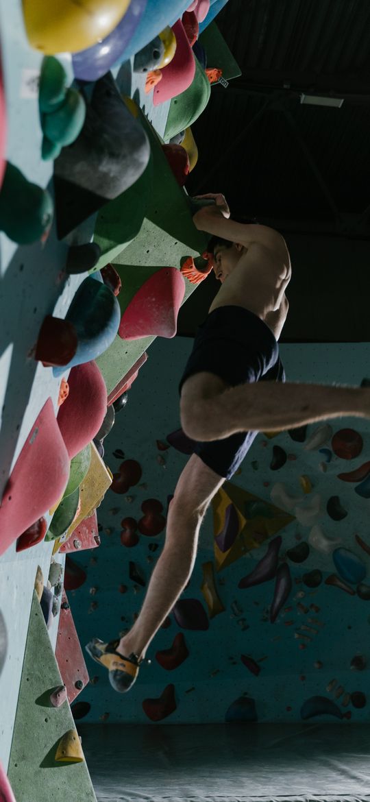 A climber moving across an indoor bouldering wall